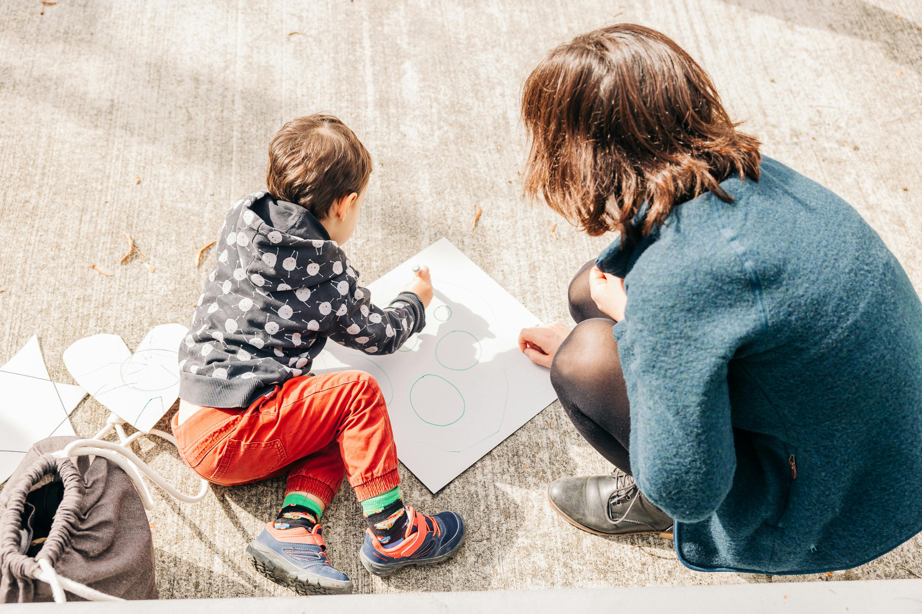 Eine Frau und ein Kind erstellen eine Kartonschablone.