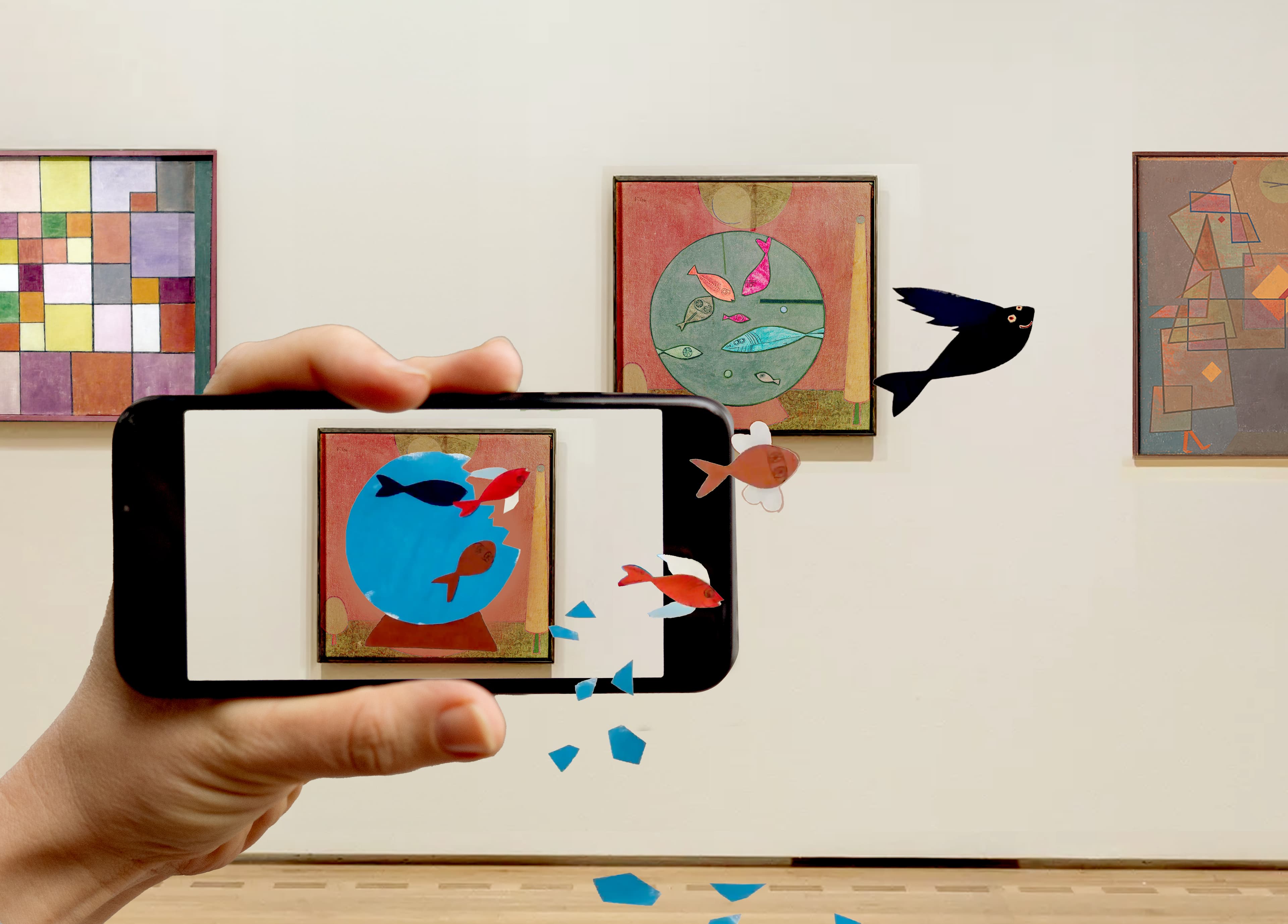 Ein Smartphonedisplay ist frontal zu sehen, das auf ein Kunstwerk von PAul Klee gerichtet ist. Auf dem Display beginnt sich das Kunstwerk zuverändern und die Fische aus dem Werk schwimmen aus dem Smartphone heraus.